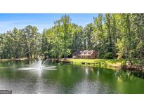 House on a pond with lush landscaping at 3110 Highway 20 W, Hampton, GA 30228