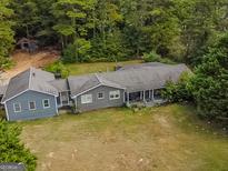 Aerial view of a ranch home with a large yard and surrounding trees at 1142 Harbins Rd, Dacula, GA 30019