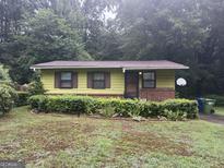 A charming yellow ranch house with a well-maintained lawn at 147 Rockyford Ne Rd, Atlanta, GA 30317