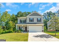 Two-story house with a gray exterior and a two-car garage at 9059 Jim Purcell Dr, Covington, GA 30014