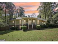 Ranch style home with covered porch and landscaped yard at 7377 Asbury Dr, Lithonia, GA 30058