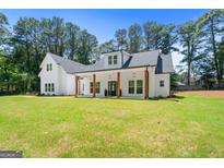 Inviting white two-story home with a covered front porch and large front yard at 3641 Pennington Se Dr, Conyers, GA 30013