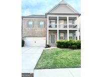 Two-story home with brick facade, two-car garage, and manicured lawn at 4020 Red Canoe Bnd, Lilburn, GA 30047