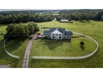 Aerial view of house on large lot with circular driveway and white fence at 1530 Highway 11, Mansfield, GA 30055