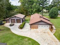 Aerial view of a ranch-style home with attached garage and large driveway at 5225 Bailey Sw Rd, Conyers, GA 30094