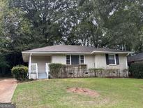 Brick ranch house with a well-maintained lawn and mature trees at 2241 Sharon Way, Decatur, GA 30032