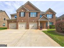 Attractive two-story brick home with a three-car garage and landscaped yard at 1263 Polk Xing, Mcdonough, GA 30252