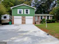 Green house with double garage and landscaping at 4139 Northstrand Dr, Decatur, GA 30035