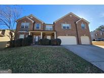 Brick two-story house with a three-car garage and landscaped lawn at 242 Old Fig Ln # 11, Fairburn, GA 30213