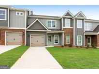 Brick and gray siding townhouse exterior with two-car garage at 1923 School House Ln, Temple, GA 30179