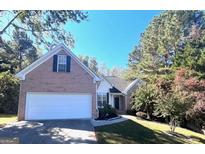 Brick house with a two-car garage and well-manicured lawn at 938 Mulberry Fields Cv, Auburn, GA 30011
