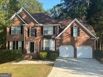 Brick two-story house with a two-car garage and lush landscaping at 508 Wynbrooke Pkwy, Stone Mountain, GA 30087