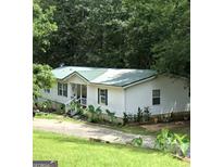 Single story home with green metal roof at 1014 Minnie Sewell Rd, Grantville, GA 30220