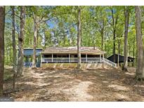House exterior with a large porch and a wooded backdrop at 1597 Leguin Mill Rd, Locust Grove, GA 30248