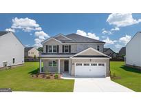 Two-story house with a white two-car garage and brick front at 660 Edgar St # 158, Hampton, GA 30228