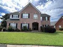 Two story brick home with a manicured lawn at 1402 Aramore Se Dr, Conyers, GA 30013