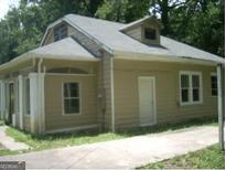 Tan house with a unique roofline and a small driveway at 2945 Palm Dr, East Point, GA 30344