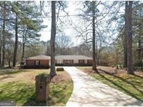 Ranch-style home with a spacious front yard and long driveway at 10219 N Dinah Cir, Covington, GA 30014