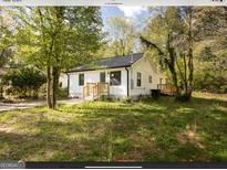 Charming white house with green door and landscaped yard at 3363 Delmar Nw Ln, Atlanta, GA 30331