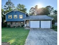 Two-story blue house with double garage and well-maintained lawn at 6091 Katherine Rd, Rex, GA 30273