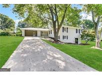 White brick ranch house with attached carport and landscaping at 6358 Joanna St, Lithia Springs, GA 30122