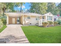 Charming ranch home with carport and manicured lawn at 3564 Glenwood Rd, Decatur, GA 30032