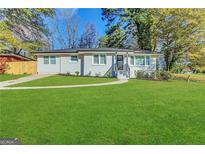 Modern white ranch house with a red door and manicured lawn at 3168 Mcafee Rd, Decatur, GA 30032