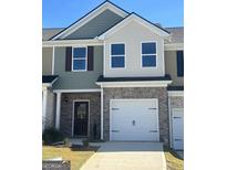 Two-story townhome with a two-car garage and neutral exterior at 8726 Lakeview Commons # 50, Jonesboro, GA 30238