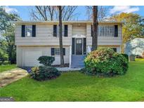Two-story home with attached garage and landscaping at 6410 Buckhurst Trl, Atlanta, GA 30349