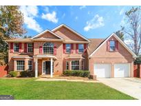 Two-story brick home with red shutters, large windows and a two-car garage at 2124 Hairston Creek Pkwy, Decatur, GA 30035
