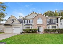 Two story house with two car garage and manicured lawn at 7546 Petal Pl, Fairburn, GA 30213