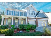 Two story home with gray siding, brick accents and rocking chairs on the porch at 1017 Preserve Park Dr, Loganville, GA 30052