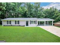Newly renovated ranch home with carport and spacious lawn at 2997 Tara Woods Dr, Douglasville, GA 30135
