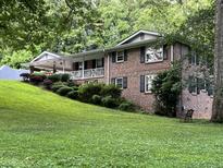 Brick house with a covered porch and landscaping at 9267 Westview Sw Dr, Covington, GA 30014