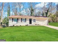 Brick ranch home with a well-maintained lawn and driveway at 2190 Westover Dr, East Point, GA 30344
