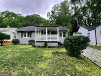 Gray house with white trim and porch, landscaped lawn at 1511 Mims Sw St, Atlanta, GA 30314