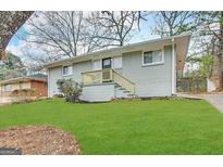 Ranch style home with gray brick exterior, steps, and a well-maintained lawn at 2233 Springdale Sw Cir, Atlanta, GA 30315