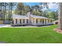 Ranch style home with a spacious lawn and carport at 245 Remington Trl, Ellenwood, GA 30294