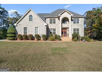 Two-story brick home with a grand entrance and manicured lawn at 2202 Escalade Ct, Conyers, GA 30094