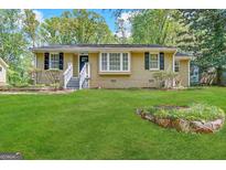 Ranch style home with landscaped yard and a white picket fence at 2413 Ben Hill Rd, East Point, GA 30344