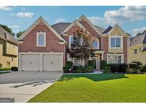 Brick two-story house with a two-car garage and landscaped lawn at 2909 Everson Ridge Ct, Snellville, GA 30039