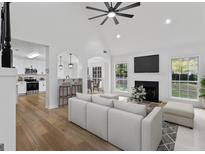 Bright living room with hardwood floors, fireplace, and kitchen view at 102 Willow Trce, Stockbridge, GA 30281