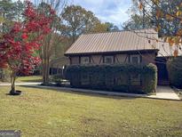 Brick ranch home with metal roof, landscaping, and carport at 2021 Brook Valley Ct, Jonesboro, GA 30236