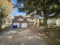 Brick house with two-car garage and landscaping at 1529 Evergreen Hollow Ln, Conyers, GA 30012