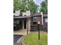 Exterior view of a townhouse with carport and small yard at 33 Cobblestone Crk, Peachtree City, GA 30269