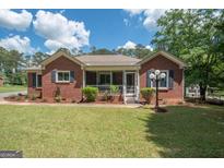 Brick ranch home with screened porch and landscaped yard at 611 Bernhard Rd, Fayetteville, GA 30215
