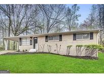 Ranch style home with brick facade, and a spacious lawn at 4906 Springbrook Dr, Douglasville, GA 30135