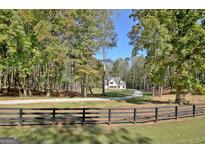 Two story house with white exterior, located on a wooded lot with long driveway at 2178 Bear Creek Rd, Moreland, GA 30259