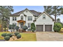 Two-story house with white exterior, landscaping, and a two-car garage at 12021 Scottish Ct, Fayetteville, GA 30215