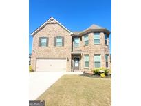 Two-story brick home with attached garage and landscaped lawn at 116 Jodi Pl, Locust Grove, GA 30248